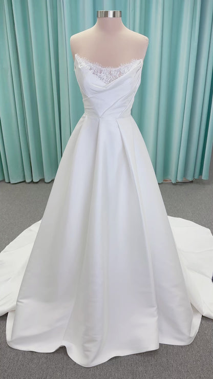 Morilee 1010001 Dove ballgown wedding dress on mannequin with strapless scoop neckline, lace peek-a-boo detail, and softly pleated skirt