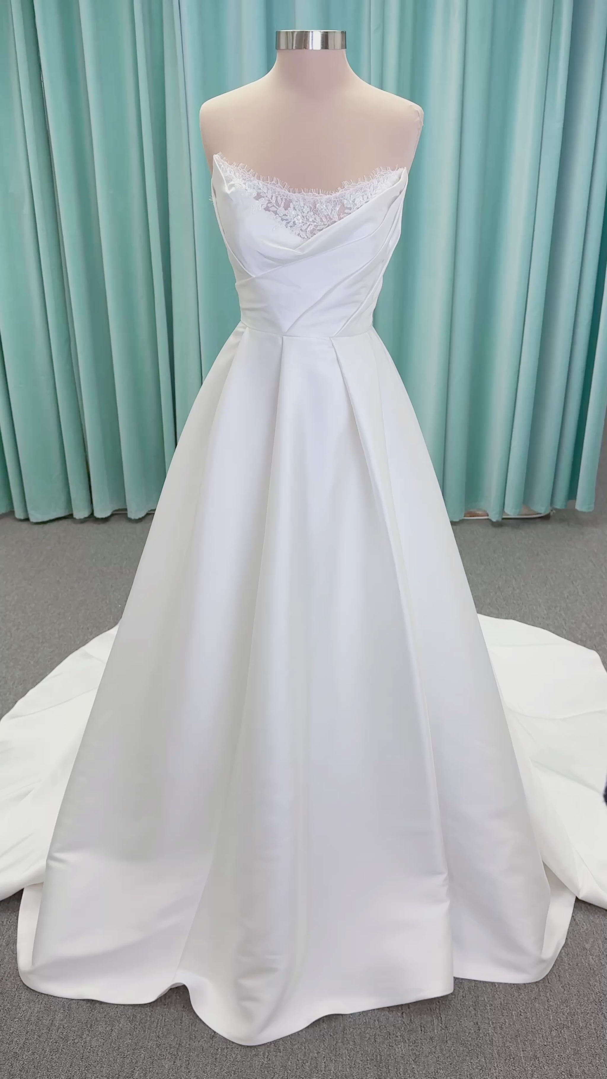 Morilee 1010001 Dove ballgown wedding dress on mannequin with strapless scoop neckline, lace peek-a-boo detail, and softly pleated skirt