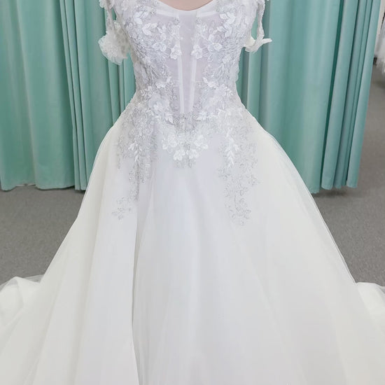 Randy Fenoli Indy A-line wedding dress on mannequin with off-the-shoulder sleeve drape, strapless sweetheart bodice, lace appliqué, basque waist, and high skirt slit