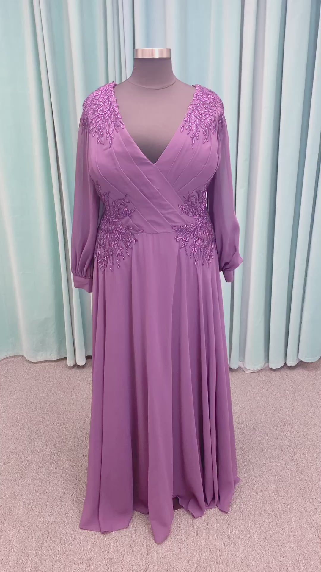 Morilee MLNY 72717 plus size A-line mother of the bride dress on mannequin with draped V-neckline, sheer bishop sleeves, beaded lace appliques at the shoulders and waist, and flowing chiffon skirt with sweep train