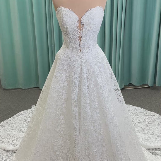 Min ivory strapless sweetheart lace A-line wedding dress on mannequin with illusion corset bodice and voluminous lace skirt.
