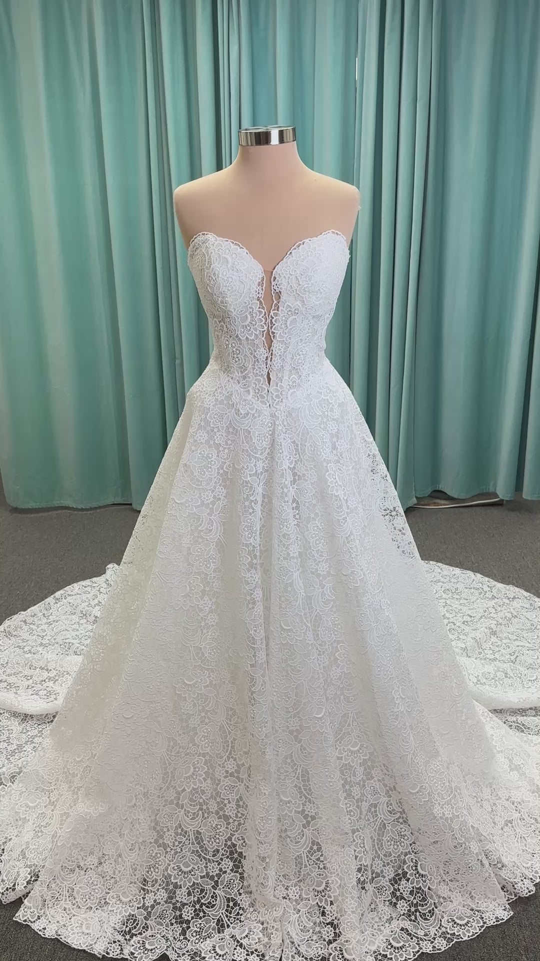 Min ivory strapless sweetheart lace A-line wedding dress on mannequin with illusion corset bodice and voluminous lace skirt.
