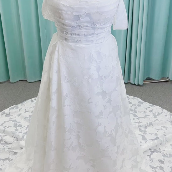Willow ivory off-the-shoulder floral jacquard A-line wedding dress on mannequin with full skirt and front slit.

