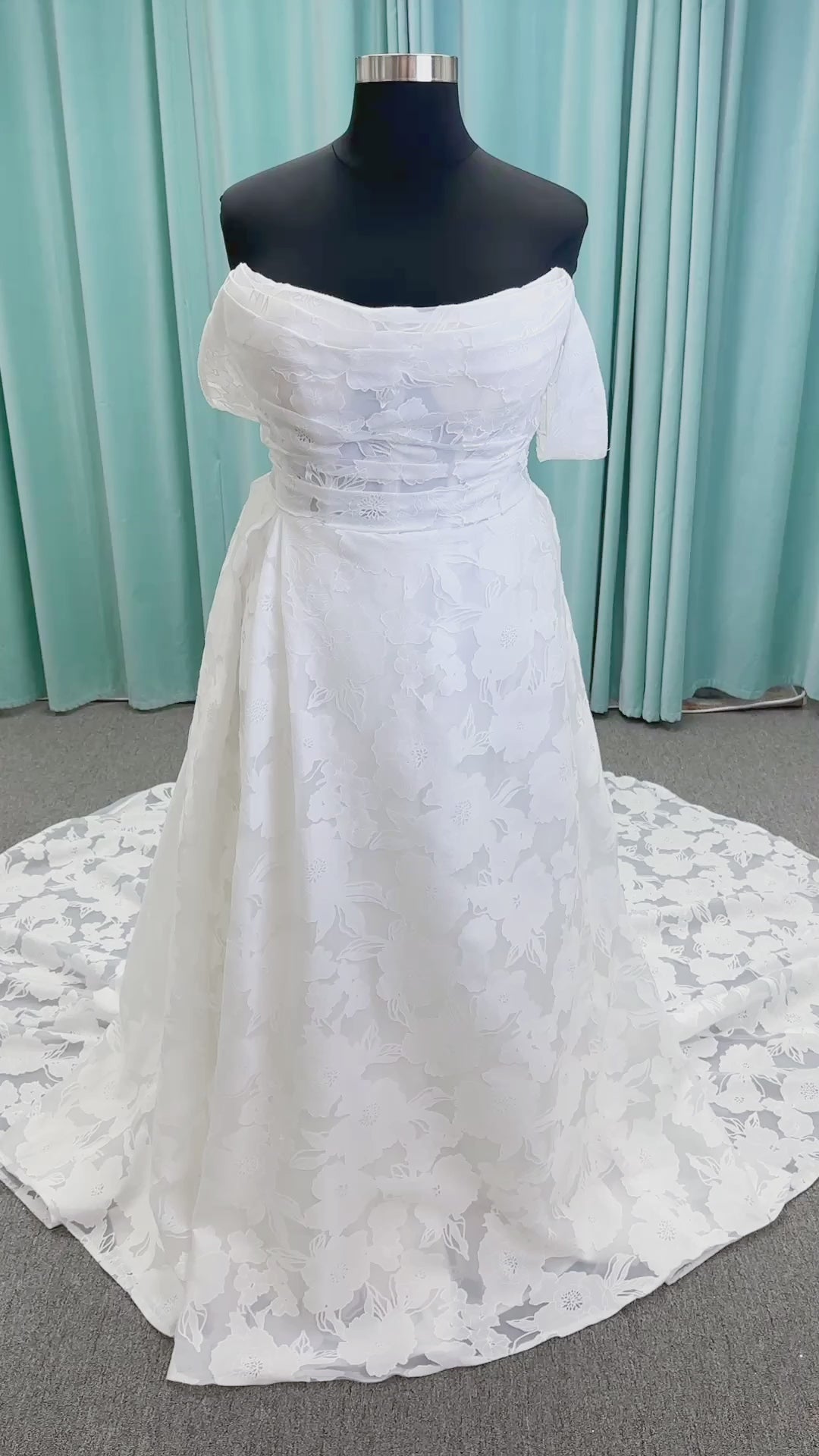 Willow ivory off-the-shoulder floral jacquard A-line wedding dress on mannequin with full skirt and front slit.
