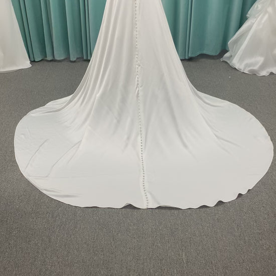 Stella York SY8110 ivory satin A-line wedding dress on mannequin with square neckline, shoulder straps, ruched bodice, and scoop back with fabric-covered buttons.
