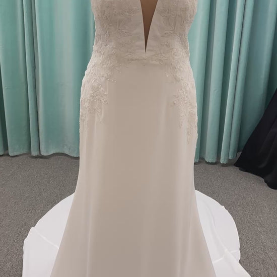 Stella York 7774 column sheath wedding dress with plunging neckline, lace appliqués, side cutouts, and crepe skirt with train