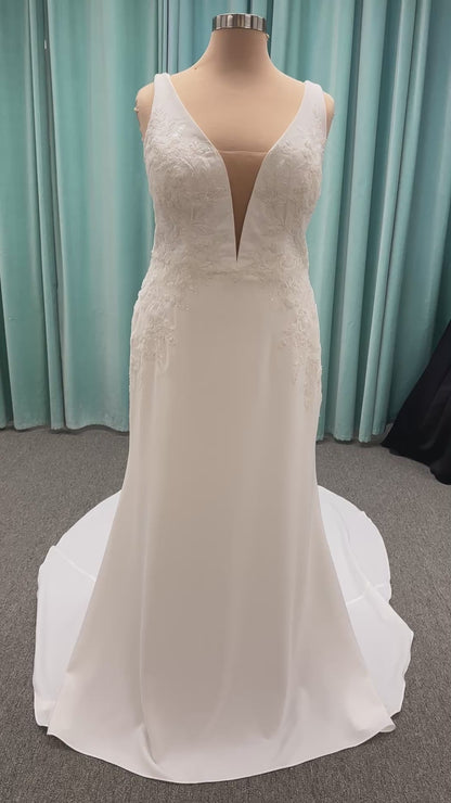 Stella York 7774 column sheath wedding dress with plunging neckline, lace appliqués, side cutouts, and crepe skirt with train