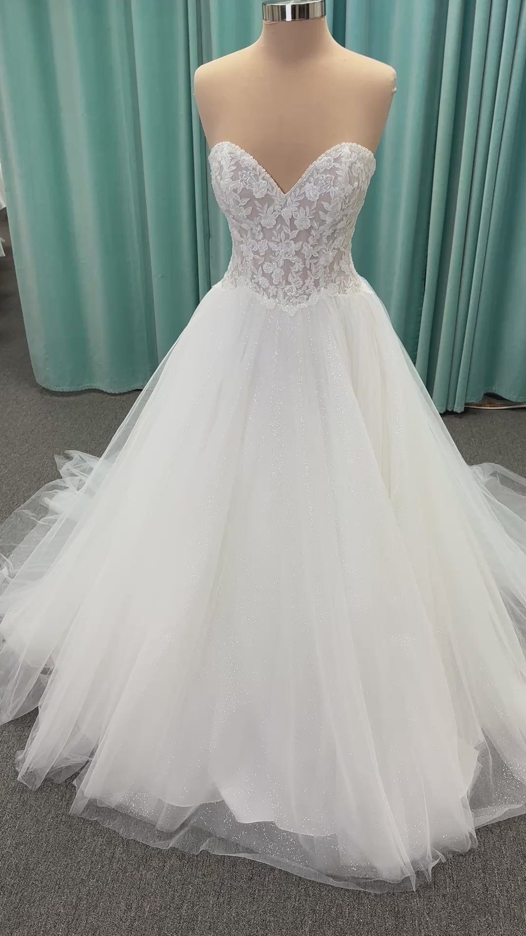 Paige ivory strapless sweetheart A-line wedding dress on mannequin with lace and tulle skirt.
