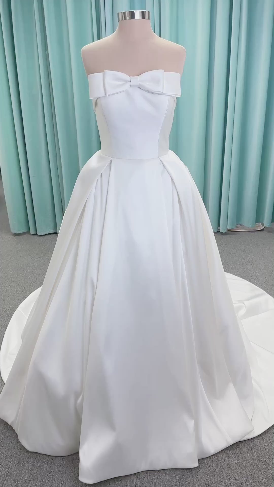 Morilee 1050011 Allegro A-line wedding dress on mannequin with strapless straight neckline, Mikado fabric, box-pleated skirt, and detachable fold-over bow