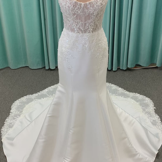 Marjorie ivory spaghetti strap wedding dress on mannequin with illusion corset bodice, floral lace appliqués, and scoop neckline.
