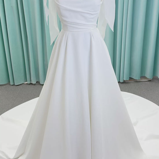 Morilee 4473 Reba A-line wedding dress in Larissa satin with cowl strapless neckline, detachable organza bow tie straps, and covered buttons to hem.
