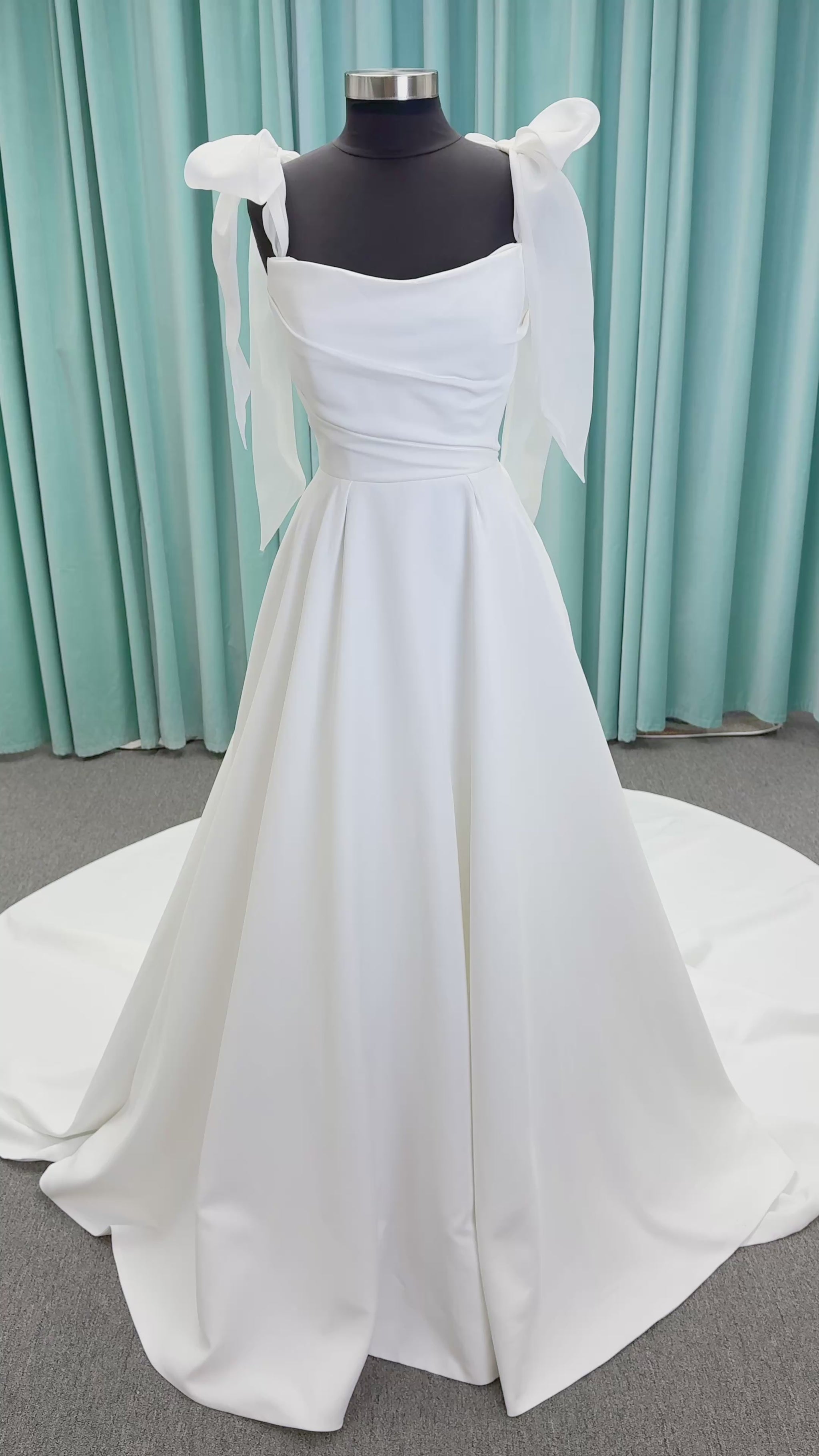 Morilee 4473 Reba A-line wedding dress in Larissa satin with cowl strapless neckline, detachable organza bow tie straps, and covered buttons to hem.