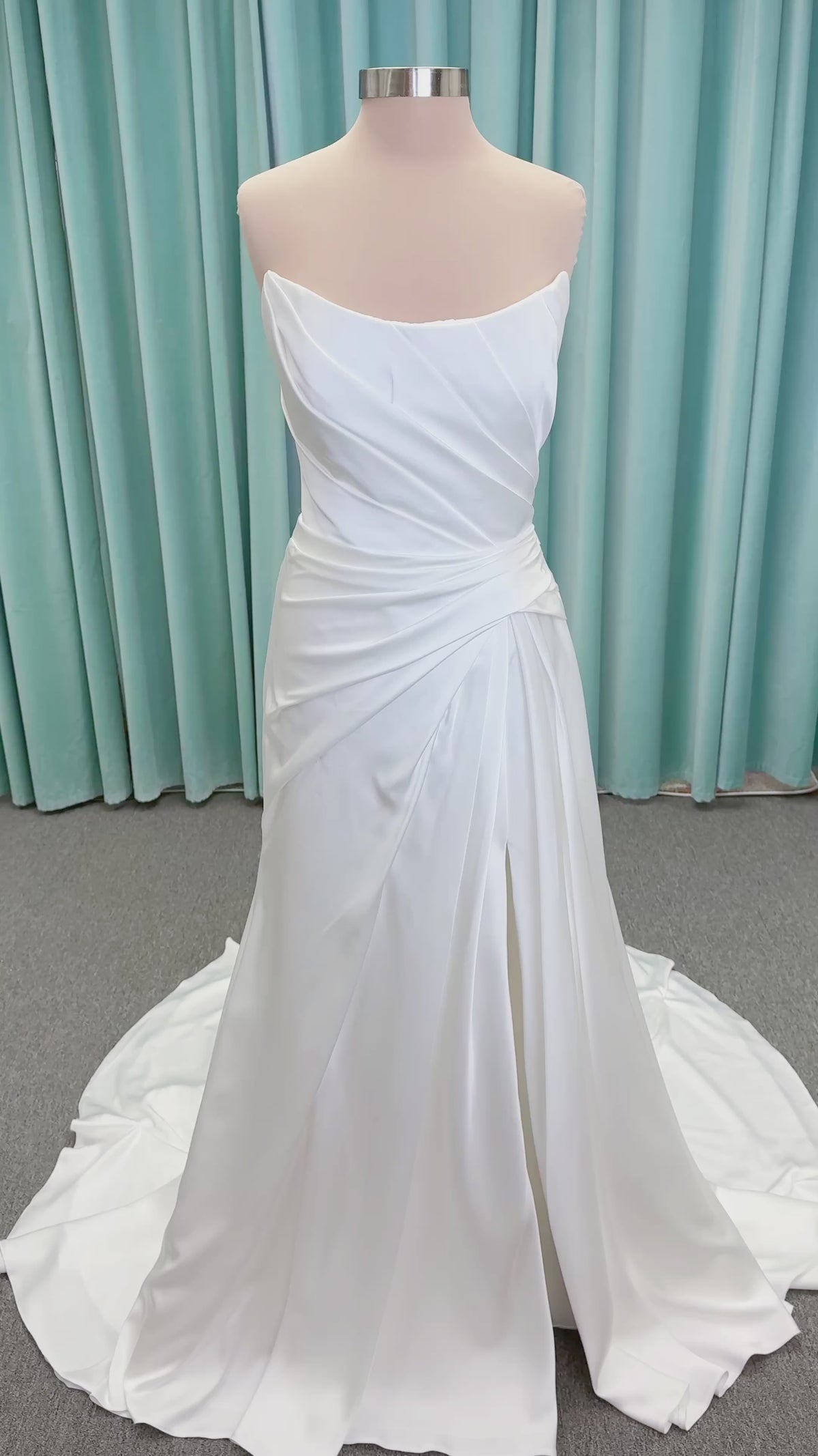 Morilee 2941 Zenobia fit and flare wedding dress on mannequin with strapless scoop neckline, asymmetric draped satin, and skirt slit