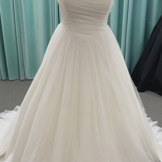 Plus size strapless A-line wedding dress with ruched tulle bodice, Chantilly lace detailing, basque waist, and flowing tulle skirt with train